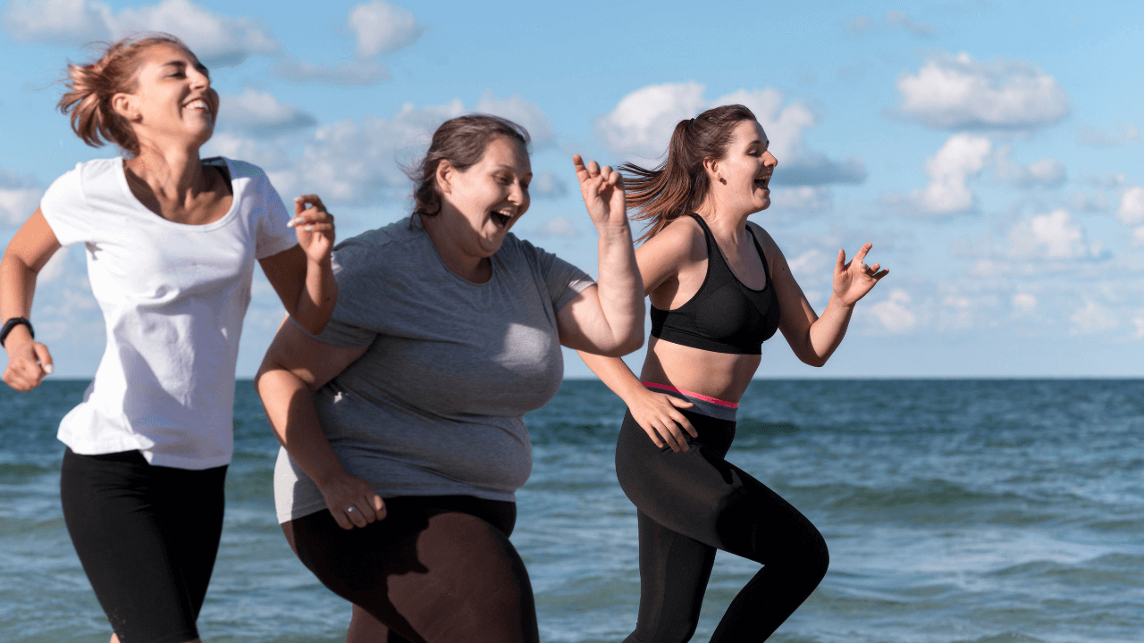 Mujeres corriendo muy felices en la orilla del mar, este tipo de actividad forma parte de los beneficios de la cirugía bariátrica